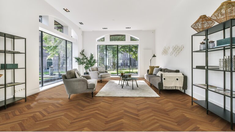 Helles Wohnzimmer mit Parkettboden im klassischen Fischgrät-Muster.